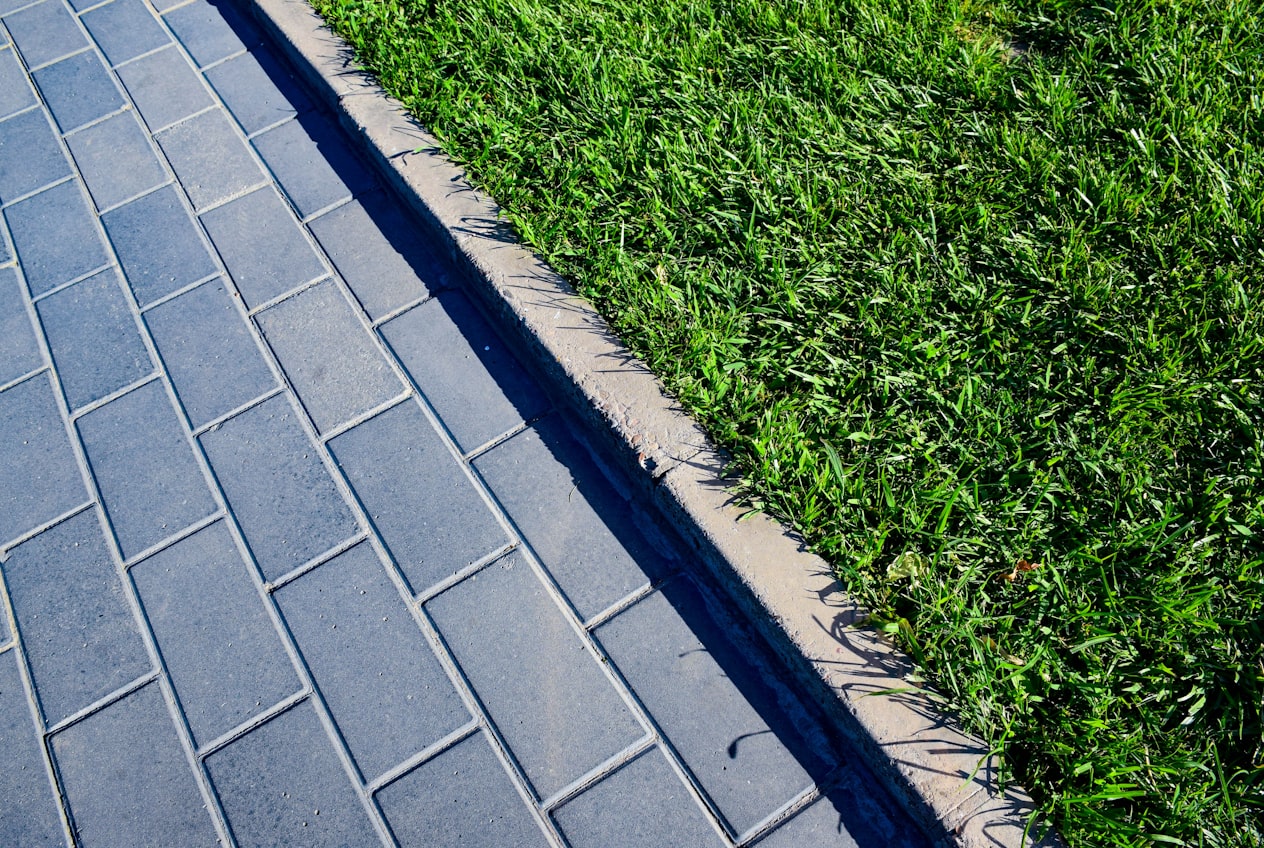 A clean paver walkway meeting a crisp, edged green lawn